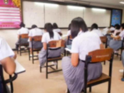 Blur  university students writing answer doing exam in classroom Stock Photos