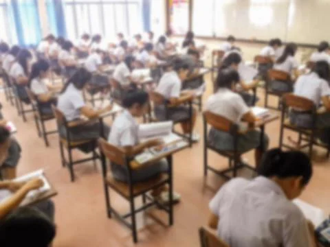 Blur  university students writing answer doing exam in classroom Stock Photos