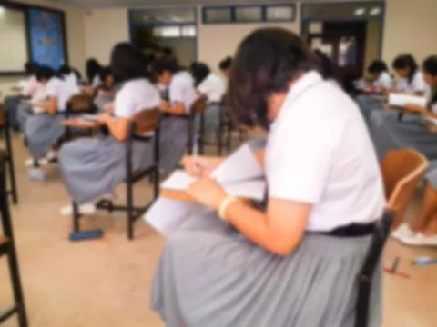 Blur  university students writing answer doing exam in classroom Stock Photos