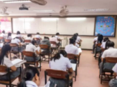 Blur  university students writing answer doing exam in classroom Stock Photos