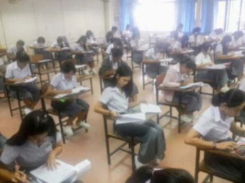 Blur  university students writing answer doing exam in classroom Stock Photos