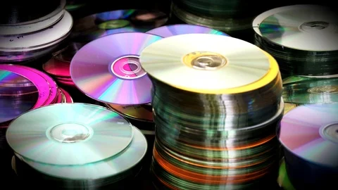 Blur view of compact optical DVD or CD Discs piles standing on table. . 4K video Stock Footage 76623630