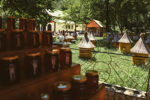Blured foreground of stack of jars with honey. apiary on background Stock-Fotos