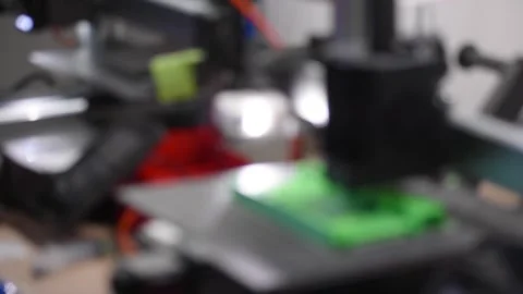 Blurred 3d printer with some objects on the tray printed with pla filament Stock Footage 304435607