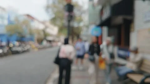 Blurred abstract view of people walking along a busy city street sidewalk. Video stock 343369004