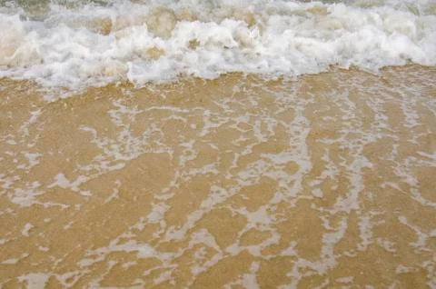 Blurred and selective focus image of wave hitting the beach Foto stock