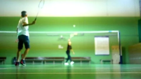 Blurred of back view of boy playing badminton with friend in badminton court. Stock Photos