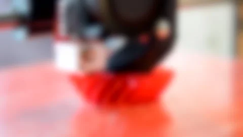 Blurred background. 3D printer makes the form, shape of red color. 動画素材 134244225