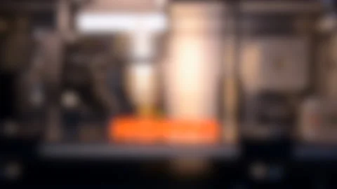 Blurred background. 3d printer printing isolated Orange object close-up. Stock Footage 137670902