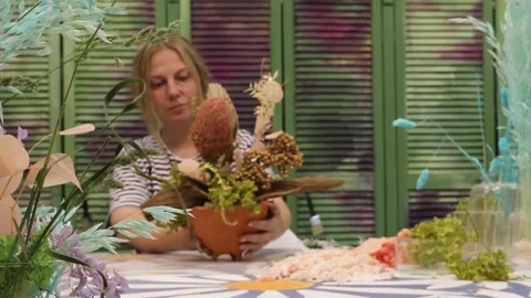 Blurred background, background, blonde florist making a bouquet of dried flowers Stock Footage 277795334