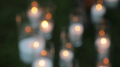 A blurred background of burning white candles, bokeh from the flames, a romantic Stock Footage 324815323