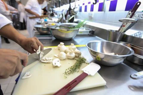 The blurred background of the chef is slicing white mushrooms on a white plas Stock Photos