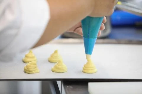 The blurred background of the chef is squeezing the cream to prepare pastries Stock Photos