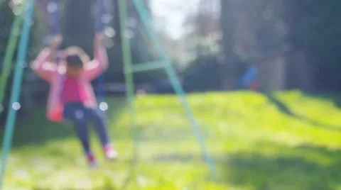 Blurred background of a child on a swing in the garden, in slow motion Vidéo 61583006