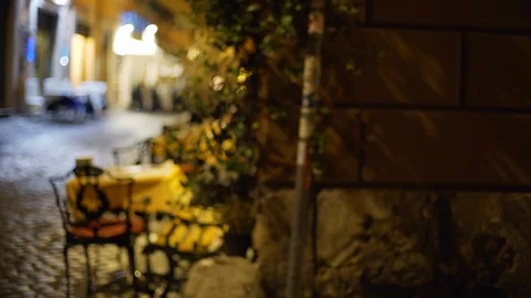 Blurred background of dark street corner with table and chairs of outdoor cafe Stock Footage 90211437