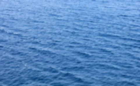 Blurred background deep blue ocean water pattern of small waves and shimmer.. Foto stock