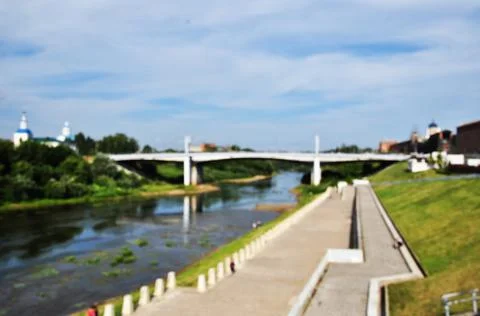 Blurred background. Defocused view of the river embankment and the bridge. Stock Photos
