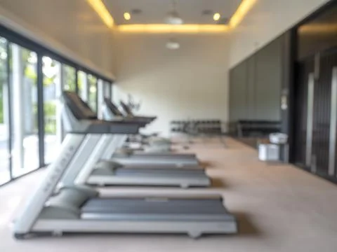 Blurred background of empty treadmills in luxury bright modern fitness gym .. Stock Photos