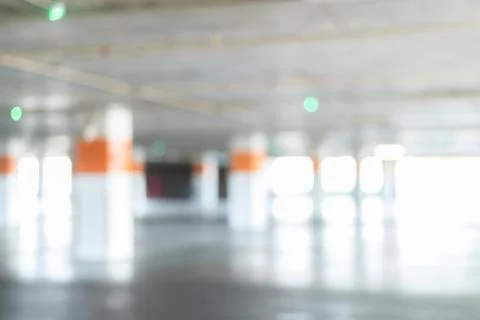 Blurred background of empty underground car parking garage - interior shot of Stock Photos