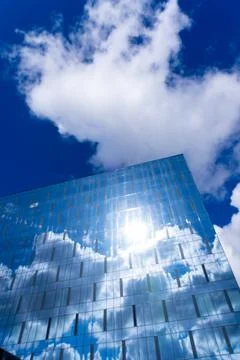 Blurred background of the facade with multiple reflections of cloudy sky Stock Photos