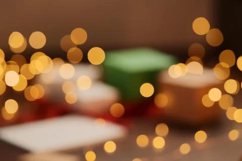 Blurred background of gift boxes and festive packaging with christmas light o Stock Photos