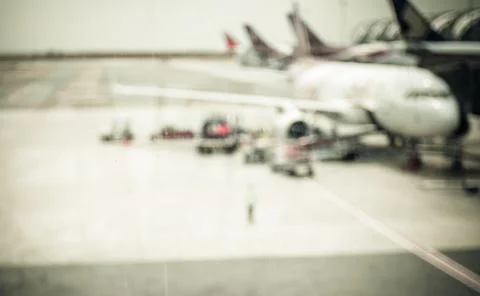 Blurred background : looking through terminal window to see airplane at airpo Stock Photos