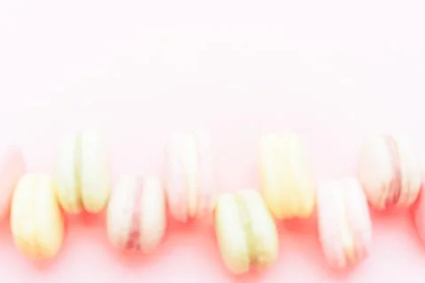 Blurred background Macaroons of different colors lie in a row against a pink Stock Photos