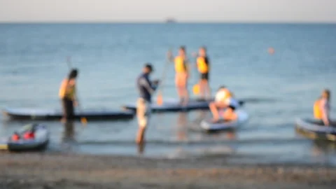 Blurred background. Many people standing and sitting swim on sup boards Stock Footage 150258973