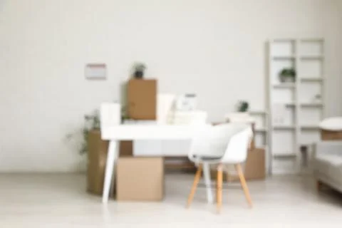 Blurred background of a modern office or home interior with moving boxes desk Stock Photos