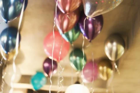 Blurred background with multicolored balloons under the ceiling. Festive concept Stock Photos