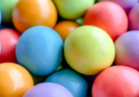 Blurred background from multicolored bright small wooden balls of blue, yellow Stock Photos