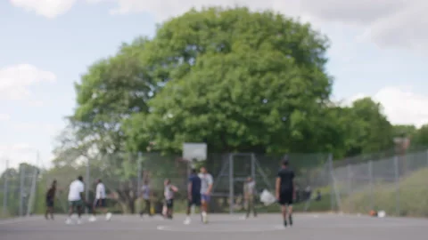 Blurred background of multiple players having a full court game of basketball on Stock Footage 136586926