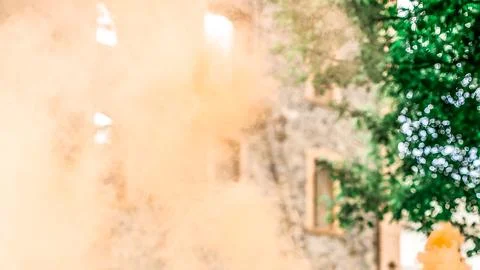 Blurred background of old city wall with bokeh and orange smoke Stock Photos