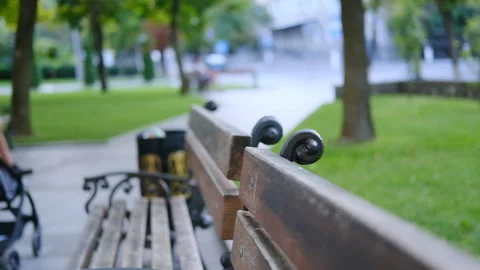 Blurred background of the park and people walking. A bench in a city park where Stock Footage 121398413