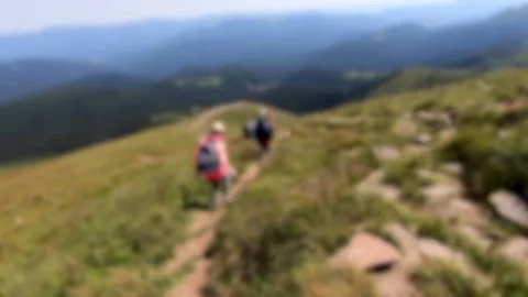 Blurred background. Person go down mountain. People walk on dirt mountain trail Stock Footage 142526601