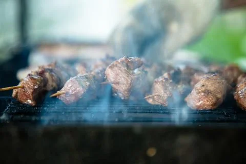 Blurred background with process of cooking pork barbecue called Shashlik in many 库存照片