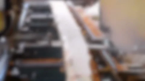 Blurred background. Process of machining logs in equipment sawmill machine Stock Footage 138001487