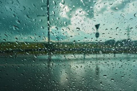 Blurred background with rain drops on car glass. Riding in the rain Stock Photos