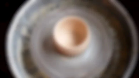 Blurred background. A raw pot of clay turns on a potter's wheel close-up. Nobody Stock Footage 136075535