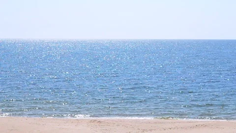 Blurred background. Sea with white sun reflections, yellow sandy beach Stock Footage 200975904