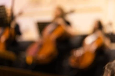 Blurred background shot of cellists playing instruments in a symphony orchest Stock Photos