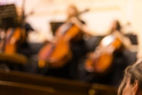Blurred background shot of cellists playing instruments in a symphony orchest Stock Photos