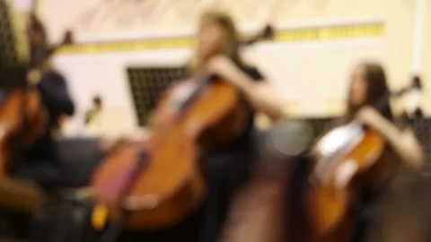 Blurred background shot of musicians playing cellos in a symphony orchestra Stock Footage 337942802