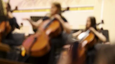 Blurred background shot of musicians playing cellos in a symphony orchestra Stock Footage 337942810