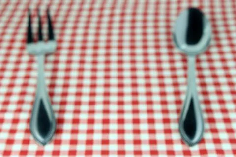 Blurred background : Silverware fork and spoon on tablecloth for food serving Stock Photos