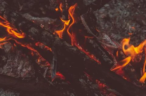 Blurred background. Small flame dying fire, bright red-orange flame. Cozy war Stock Photos