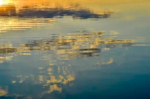 Blurred, background the surface of the water with the reflection of the eveni Stock Photos