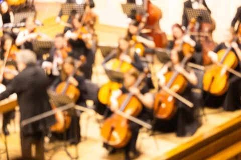 Blurred background of a symphony orchestra with conductor performing on sta.. Stock Photos