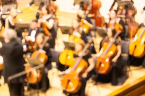 Blurred background of a symphony orchestra with conductor performing on sta.. Stock Photos