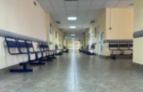 Blurred background, View of an empty hospital corridor with visitor chairs. Stock Photos